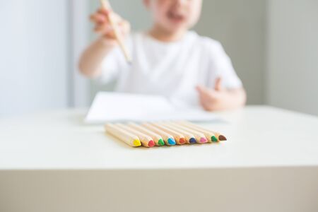 Little cute boy drawing with pencils at homeの写真素材