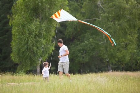 Father and son relationship, playing with kite in the parkの写真素材