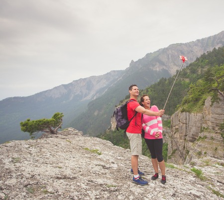 Young traveler couple taking a selfie picture on top of a mountainの写真素材