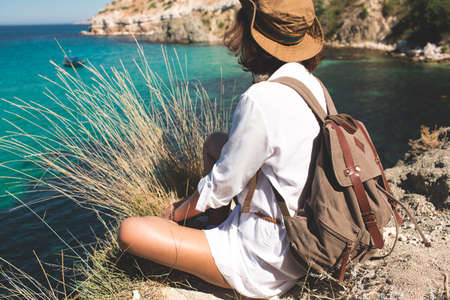 Backpack traveler woman standing on sea cliff .