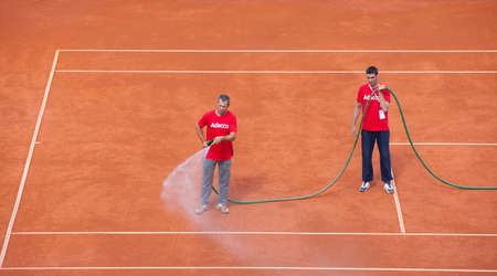 BELGRADE, SERBIA - JULY 16 . Staff waters tennis court on the quaterfinal of Davis Cup 2016 on july 16, 2016 in Belgrade, Serbiaのeditorial素材