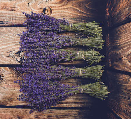 Five lavender bunch laying over wood background.の写真素材