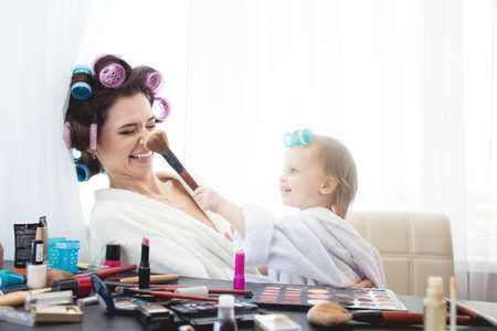 Happy family. Mother and daughter are doing hair, manicures, makeup and having fun. Mother and...
