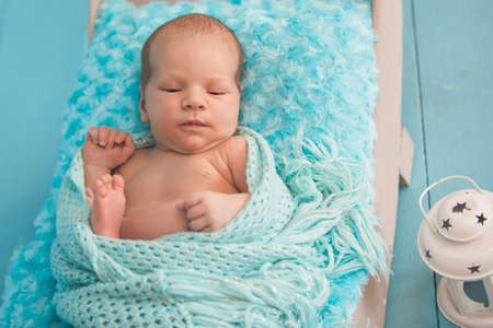 Studio portrait of newborn baby boy sleeping in bed.の写真素材