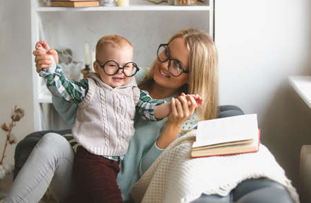 Happy family. mother and her cute son reading book near the windowの写真素材