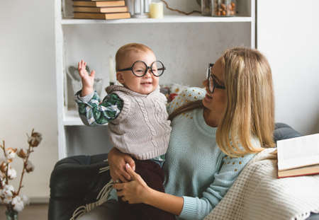 Happy family. mother and her cute son reading book near the windowの写真素材