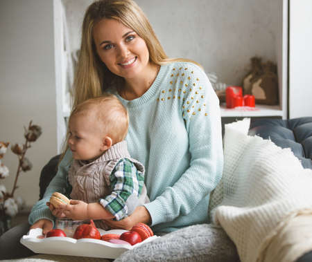 Happy family. mother and her cute son sitting on the sofa near the windowの写真素材