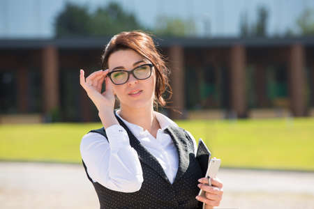 Portrait of a young smiling business woman with phoneの写真素材