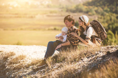 Family on autumn hike. Young parents with kid hiking next to a mountain.の写真素材