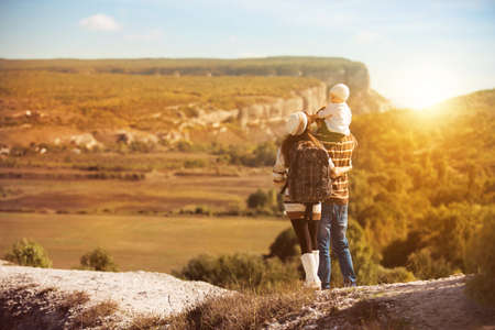 Family on autumn hike. Young parents with kid hiking next to a mountain.の写真素材