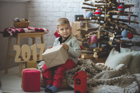 Portrait of little boy near fashion xmas tree