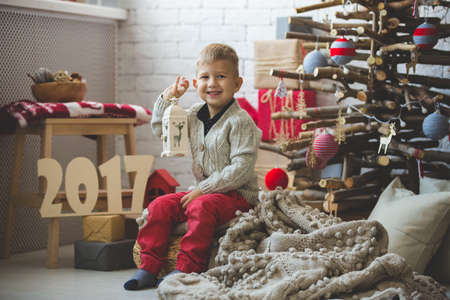 Portrait of little boy near fashion xmas tree
