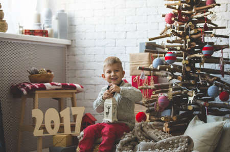 Portrait of little boy near fashion xmas treeの写真素材