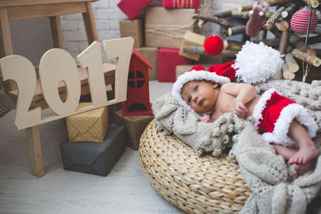 Portrait of sleeping newborn baby boy in Santa clothesの写真素材