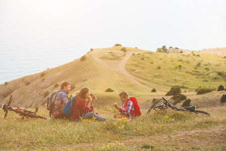 happy family of four people eating fastfoodl in mountains. family conceptの写真素材