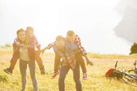 family concept. happy family of four people riding bikes at the mountainの写真素材