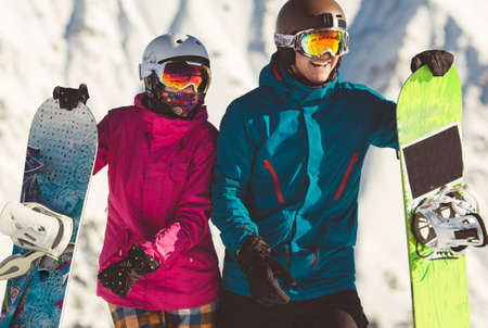 Happy couple of snowboarders in the alpine mountainsの写真素材