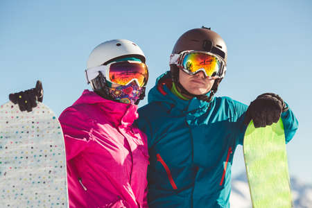 Happy couple of snowboarders in the alpine mountainsの写真素材
