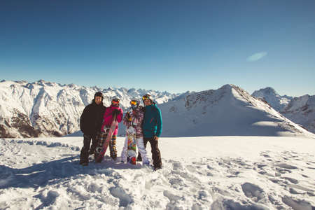 Snowboarders in colorful jackets have fun in the alpine mountains. snowboarding concept.の写真素材