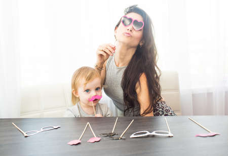 Mother and her daughter with a paper accessories.の写真素材