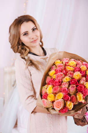 Smiling girl with bouquet of roses.の写真素材