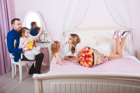 Young loving family portrait in bedroomの写真素材