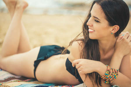 Beautiful young girl in bikini swimsuit rest on the beach