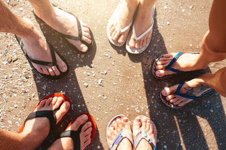 Five pare of legs on the sand of the beachの写真素材