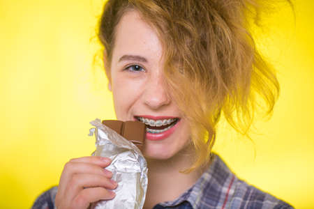 Young girl in a plaid shirt showing her dental bracesの写真素材