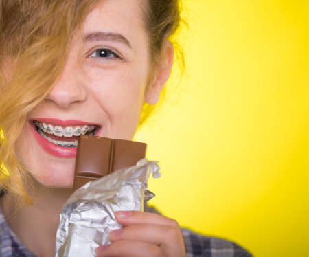 Young girl in a plaid shirt showing her dental bracesの写真素材