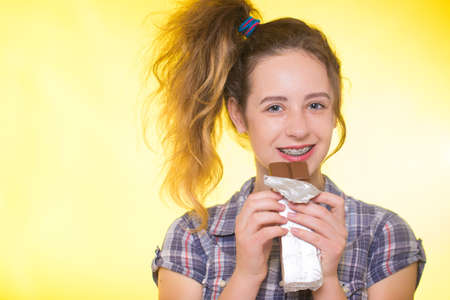 Young girl in a plaid shirt showing her dental bracesの写真素材