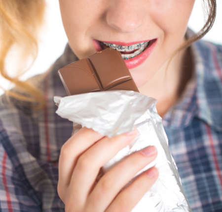 Young girl in a plaid shirt showing her dental braces