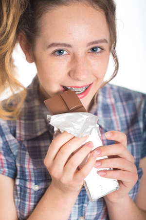 Young girl in a plaid shirt showing her dental bracesの写真素材
