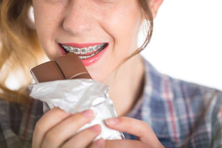 Young girl in a plaid shirt showing her dental bracesの写真素材
