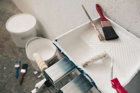 Buckets with paint and brushes stand near the wall. Accessories for repairの写真素材