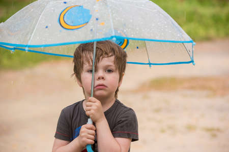 Little boy under umbrellaの写真素材