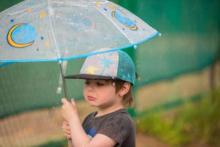 Little boy under umbrellaの写真素材