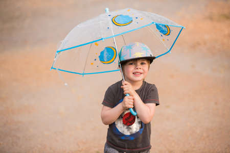 Little boy under umbrellaの写真素材