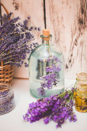 Lavender oil with fresh flowers on wooden background.の写真素材