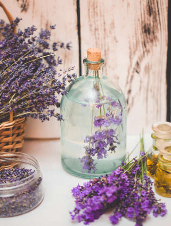 Lavender oil with fresh flowers on wooden background.の写真素材