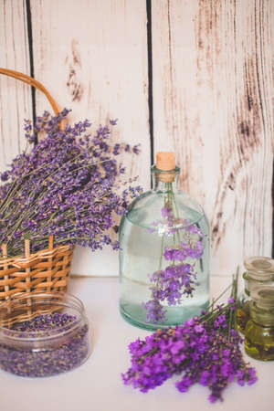 Lavender oil with fresh flowers on wooden background.の写真素材