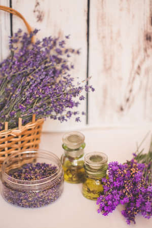 Lavender oil with fresh flowers on wooden background.の写真素材