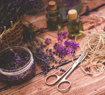 Lavender oil with fresh flowers on wooden background.の写真素材