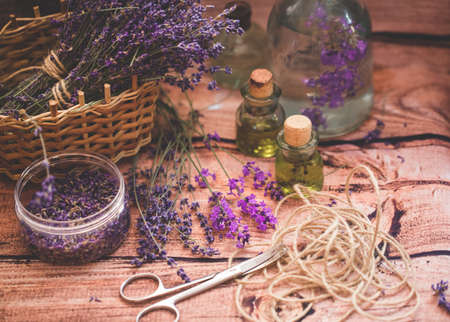 Lavender oil with fresh flowers on wooden background.の写真素材