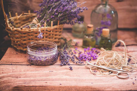 Lavender oil with fresh flowers on wooden background.の写真素材