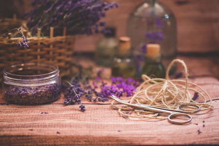 Lavender oil with fresh flowers on wooden background.の写真素材