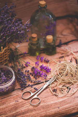 Lavender oil with fresh flowers on wooden background.の写真素材
