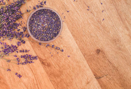 Lavender oil with fresh flowers on wooden background.の写真素材