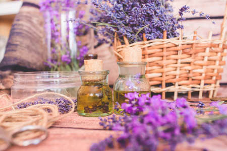 Lavender oil with fresh flowers on wooden background.の写真素材