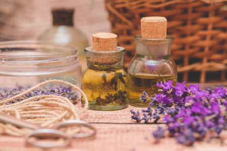Lavender oil with fresh flowers on wooden background.の写真素材
